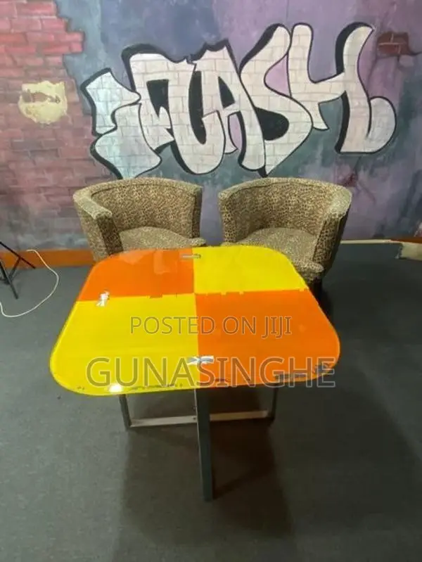 Two wooden chairs with Glass top table